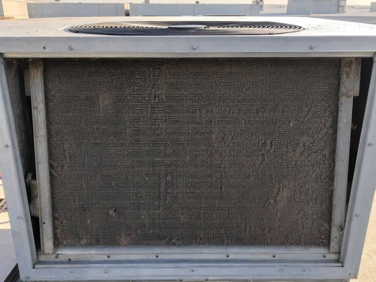 Commercial condenser coil blocked with dust and lint before maintenance